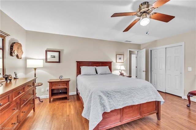 bedroom with ceiling fan, light hardwood / wood-style floors, and a closet