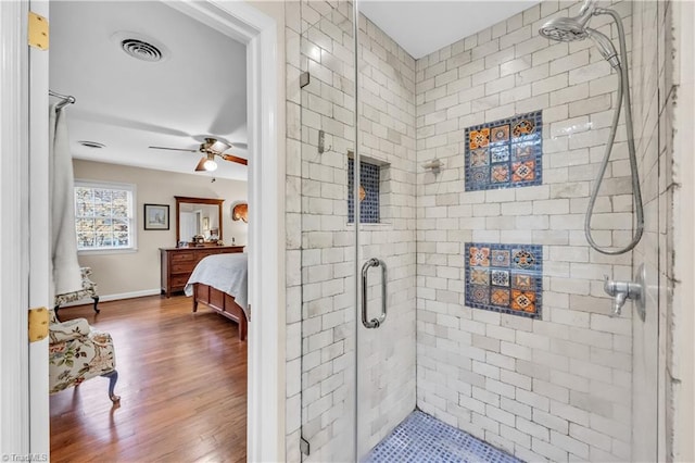 bathroom with hardwood / wood-style flooring, an enclosed shower, and ceiling fan