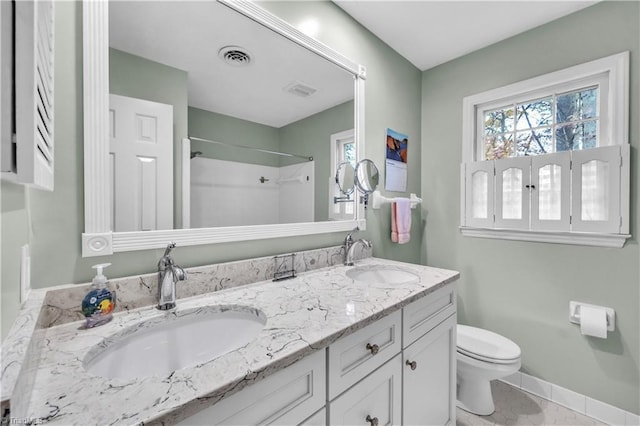 bathroom featuring a shower, vanity, toilet, and tile patterned flooring