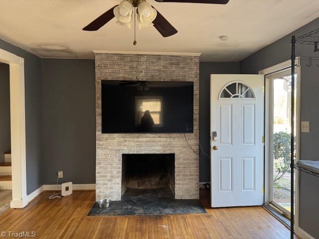 unfurnished living room featuring hardwood / wood-style flooring, a fireplace, and ceiling fan