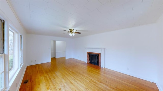 unfurnished living room featuring light hardwood / wood-style floors, ceiling fan, and a fireplace