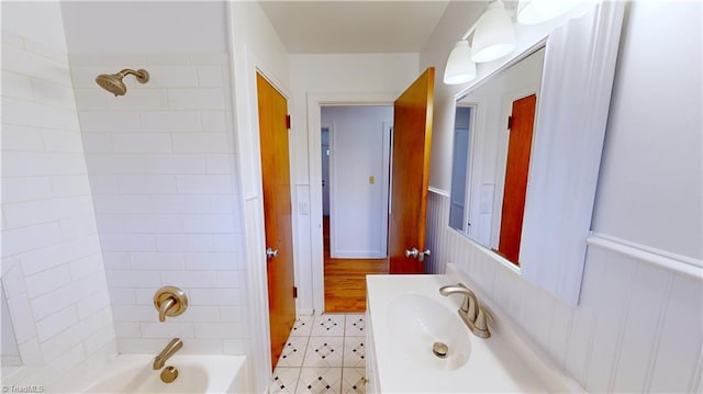 bathroom featuring tiled shower / bath, tile patterned floors, and vanity