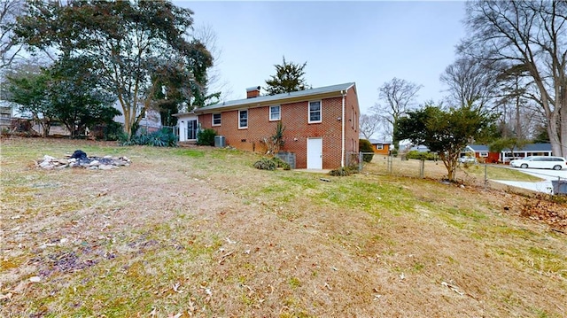 exterior space with central AC unit and a yard