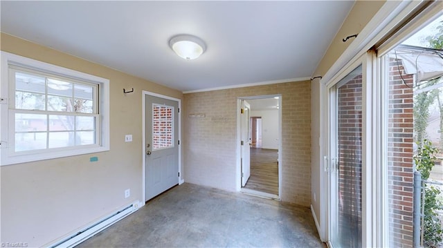 entryway with concrete floors, brick wall, and a baseboard heating unit