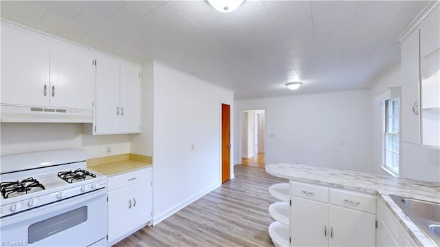 kitchen featuring white cabinets, white gas stove, and light hardwood / wood-style flooring