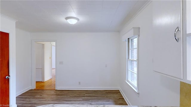 empty room featuring hardwood / wood-style floors and ornamental molding