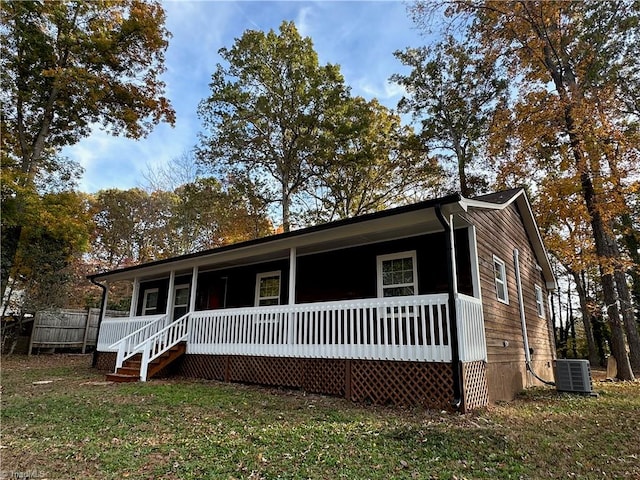 view of front of property featuring a front yard, a porch, and central AC