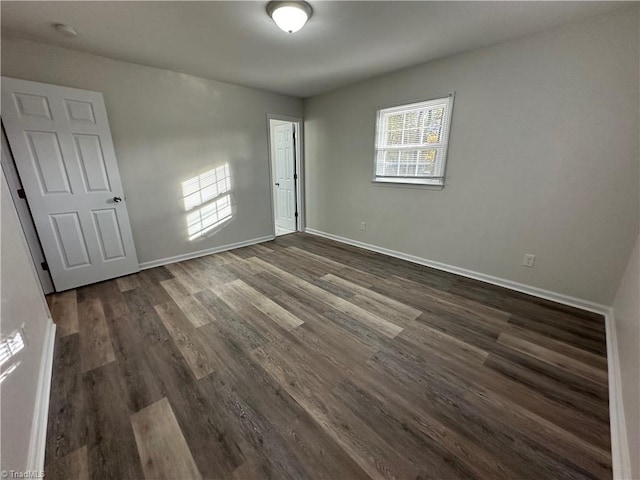 empty room with dark hardwood / wood-style flooring