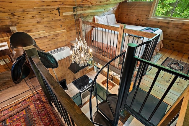 staircase featuring wooden walls and an inviting chandelier