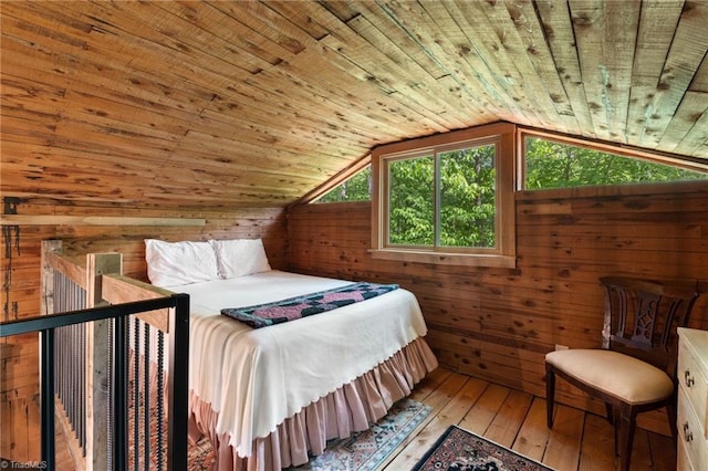 bedroom featuring wood walls, wood ceiling, vaulted ceiling, and hardwood / wood-style floors