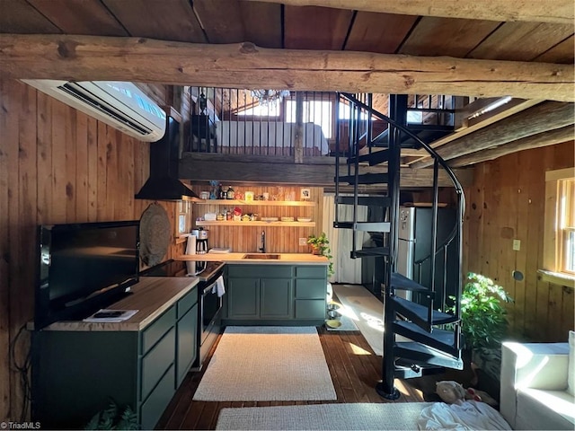 bar featuring a sink, wood walls, stairs, and dark wood-type flooring