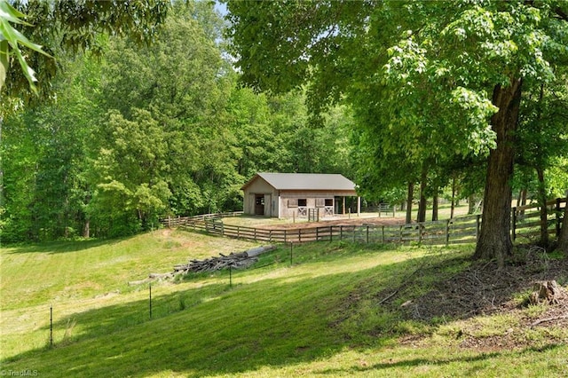 view of yard with an exterior structure, a forest view, and an outbuilding