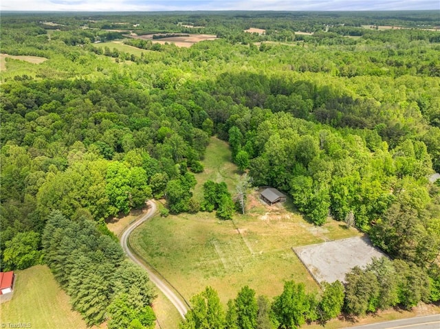 drone / aerial view featuring a wooded view