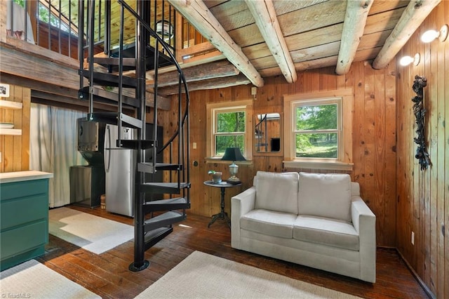 living room with stairway, wood walls, beam ceiling, and dark wood-style floors