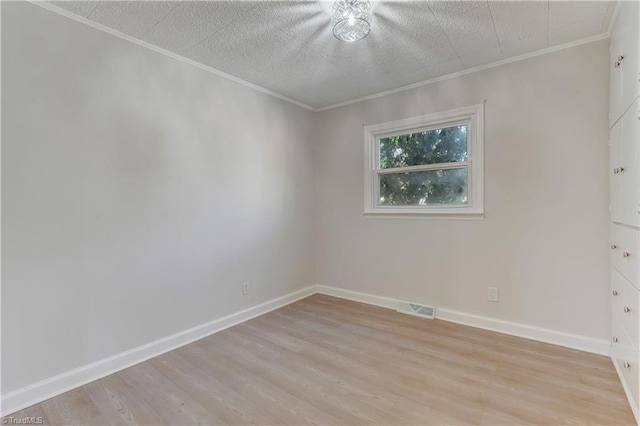 unfurnished room featuring light wood-type flooring, baseboards, visible vents, and crown molding