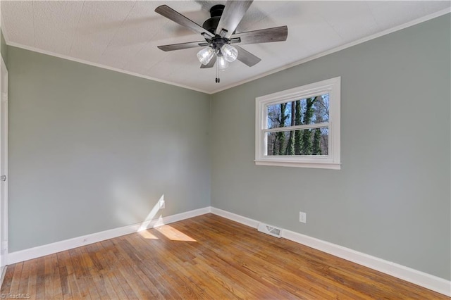 spare room with baseboards, visible vents, ceiling fan, ornamental molding, and hardwood / wood-style floors