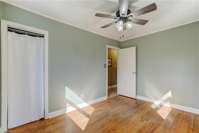 unfurnished bedroom featuring ornamental molding, baseboards, and hardwood / wood-style floors