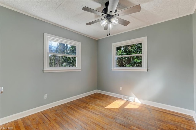 spare room with hardwood / wood-style flooring, plenty of natural light, and baseboards