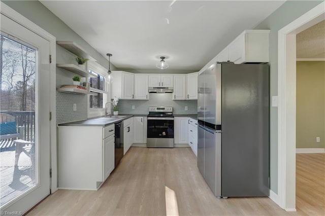 kitchen with under cabinet range hood, white cabinetry, stainless steel appliances, and a wealth of natural light