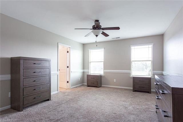 unfurnished bedroom with ceiling fan, light colored carpet, and multiple windows