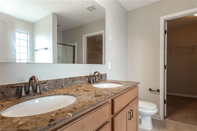 bathroom with double sink vanity, tile patterned floors, and toilet