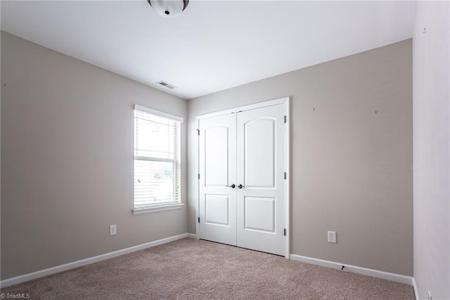 unfurnished bedroom featuring carpet floors and a closet