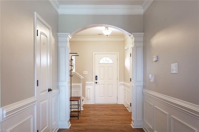 interior space featuring ornate columns, crown molding, and wood-type flooring