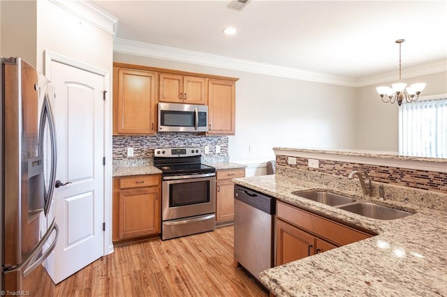 kitchen with appliances with stainless steel finishes, sink, tasteful backsplash, light hardwood / wood-style floors, and a chandelier