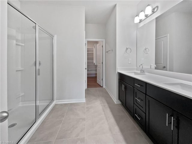 bathroom with tile patterned floors, a shower with door, and vanity