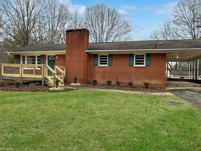 rear view of property with a yard and a carport