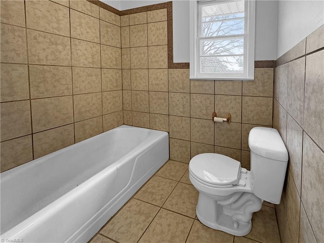 bathroom featuring tile patterned flooring, a bath, tile walls, and toilet