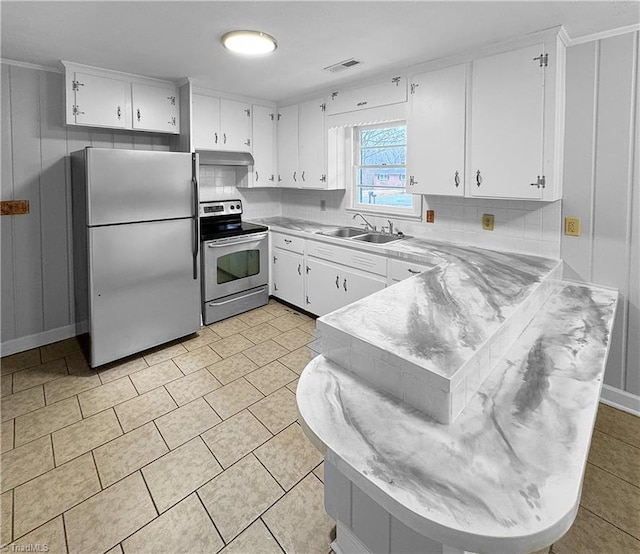 kitchen featuring backsplash, white cabinets, sink, kitchen peninsula, and stainless steel appliances