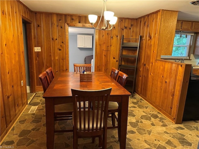 2765 Green Oaks Dr, Winston-Salem, NC 27107 - dining space with wood walls, stone finish flooring, and a chandelier