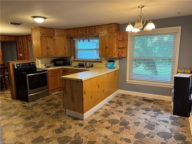 2765 Green Oaks Dr, Winston-Salem, NC 27107 - kitchen featuring stainless steel range with electric stovetop, stone flooring, a peninsula, a chandelier, and light countertops