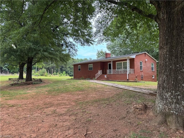 2765 Green Oaks Dr, Winston-Salem, NC 27107 - view of front of home featuring covered porch, brick siding, a chimney, and a front lawn