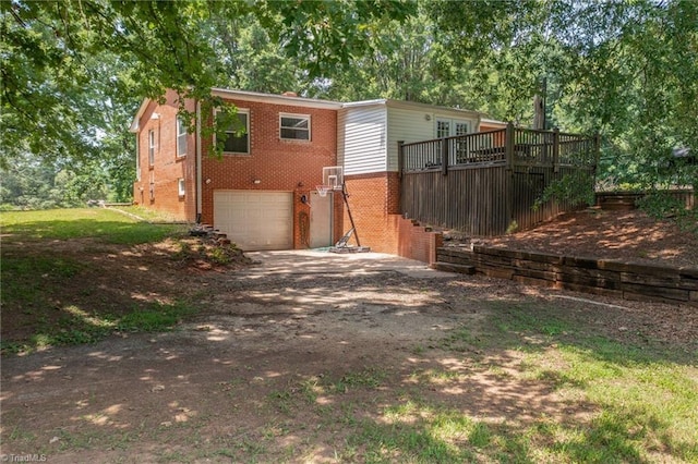 2765 Green Oaks Dr, Winston-Salem, NC 27107 - back of house with brick siding, dirt driveway, an attached garage, and a deck