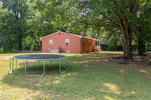 2765 Green Oaks Dr, Winston-Salem, NC 27107 - view of green lawn with a trampoline and view of wooded area