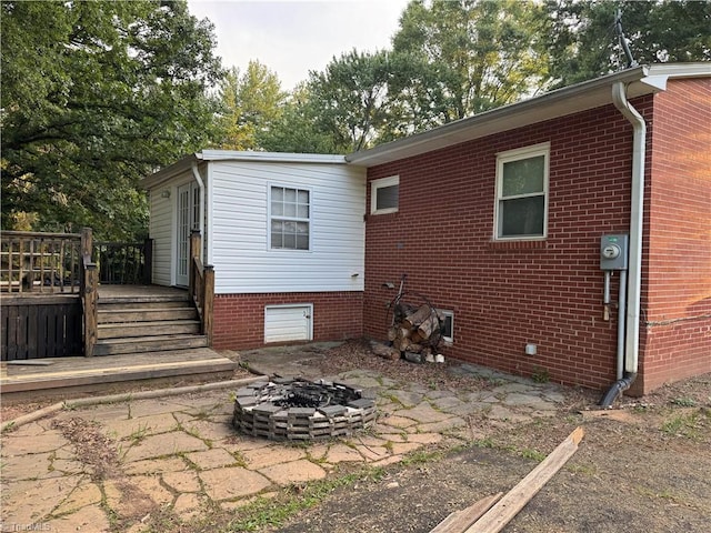 2765 Green Oaks Dr, Winston-Salem, NC 27107 - back of property featuring a fire pit, a wooden deck, and brick siding