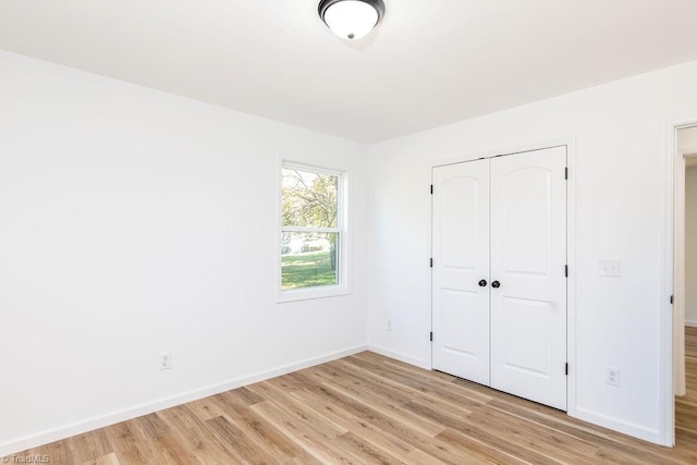 unfurnished bedroom featuring light hardwood / wood-style flooring and a closet