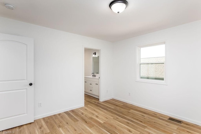 spare room with sink and light hardwood / wood-style floors