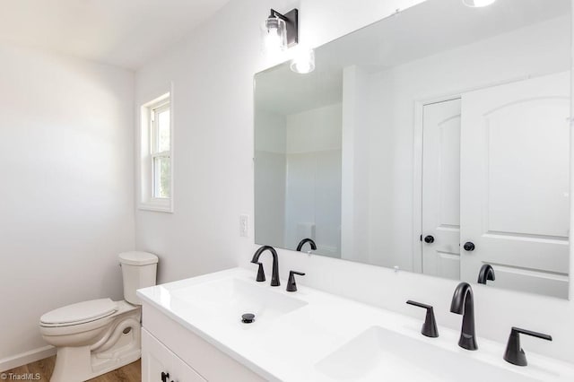 bathroom featuring vanity, wood-type flooring, and toilet