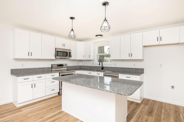 kitchen with white cabinetry, stainless steel appliances, and light wood-type flooring