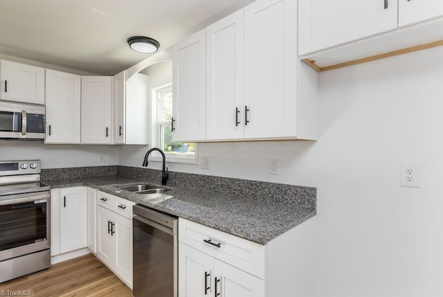 kitchen featuring sink, white cabinetry, light hardwood / wood-style flooring, and stainless steel appliances