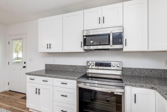 kitchen featuring white cabinets, stainless steel appliances, and wood-type flooring