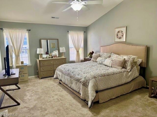 carpeted bedroom with a ceiling fan, visible vents, vaulted ceiling, and baseboards