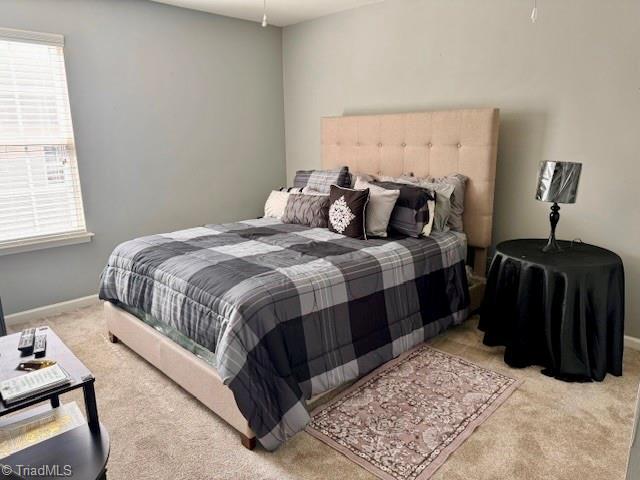 bedroom with multiple windows, carpet flooring, and baseboards