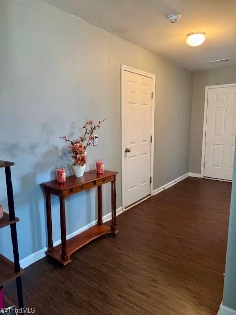 hallway featuring wood finished floors and baseboards