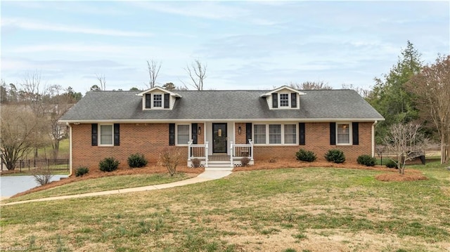 cape cod home with a porch, a front yard, brick siding, and fence