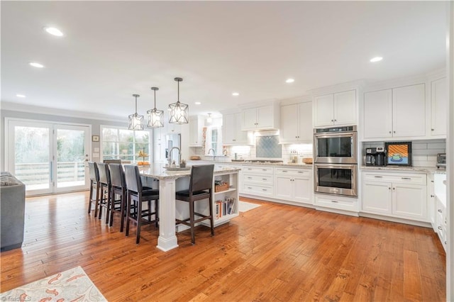 kitchen featuring appliances with stainless steel finishes, white cabinets, and backsplash