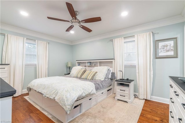 bedroom featuring baseboards, multiple windows, wood finished floors, and crown molding